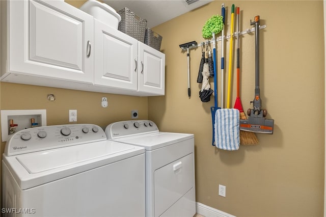 washroom featuring cabinets and washer and dryer