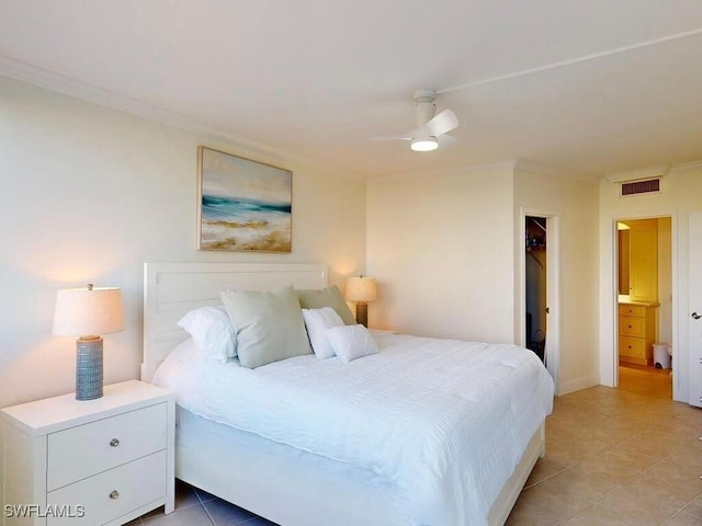 tiled bedroom with ceiling fan, ornamental molding, ensuite bath, and a walk in closet