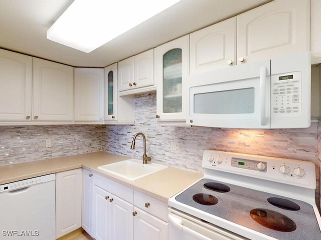 kitchen with white appliances, sink, decorative backsplash, and white cabinets