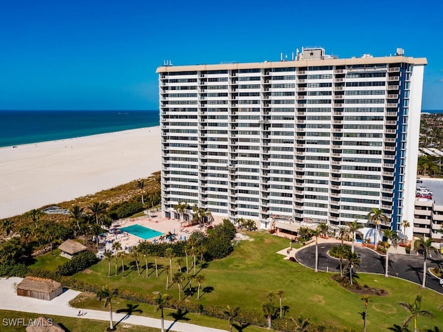 view of building exterior with a beach view and a water view
