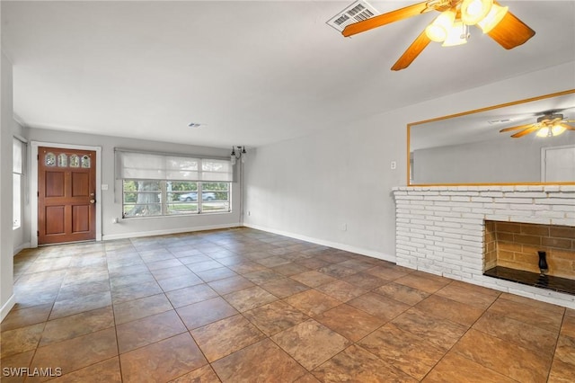 unfurnished living room with ceiling fan and a brick fireplace