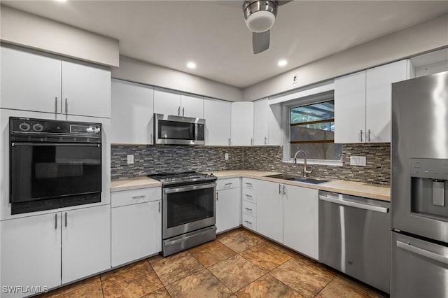 kitchen with stainless steel appliances, white cabinetry, sink, and tasteful backsplash