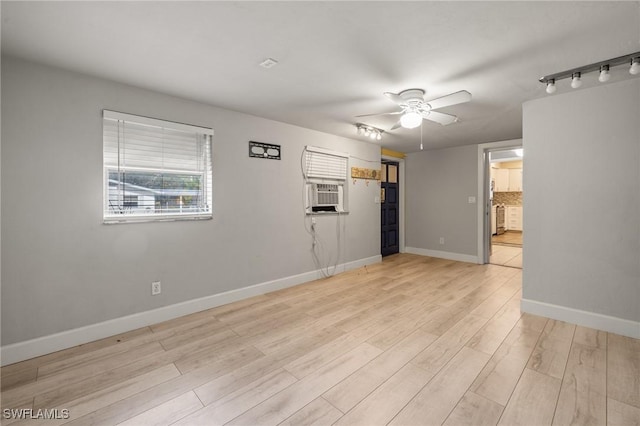 empty room with ceiling fan, cooling unit, and light hardwood / wood-style floors