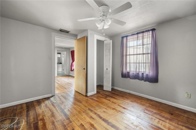 unfurnished bedroom with hardwood / wood-style flooring, ceiling fan, and a closet