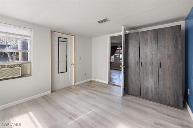 foyer featuring cooling unit, a healthy amount of sunlight, and light wood-type flooring