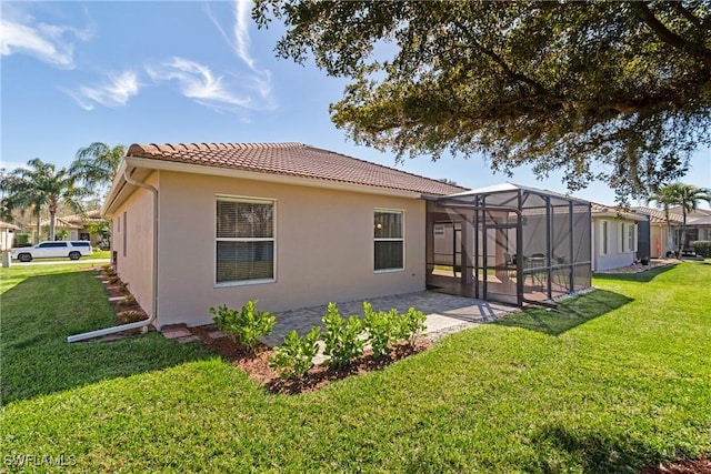 rear view of property featuring a lanai, a lawn, and a patio area