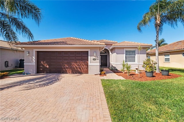 mediterranean / spanish home with a garage, cooling unit, and a front lawn