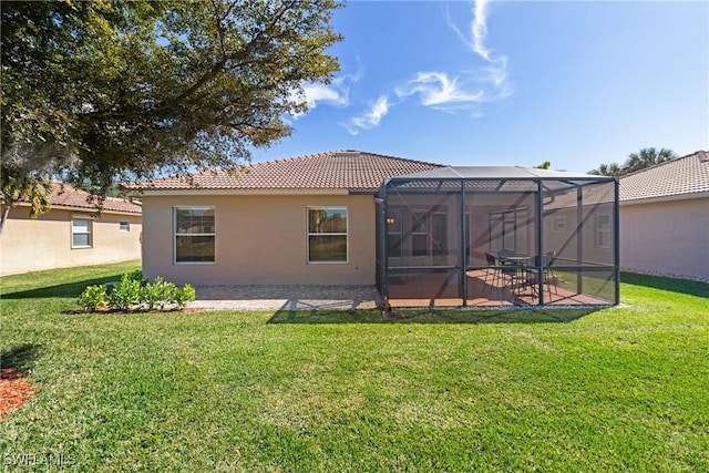 back of property featuring a yard, a lanai, and a patio