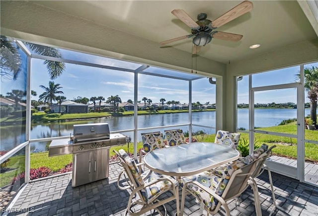 sunroom with a water view and ceiling fan