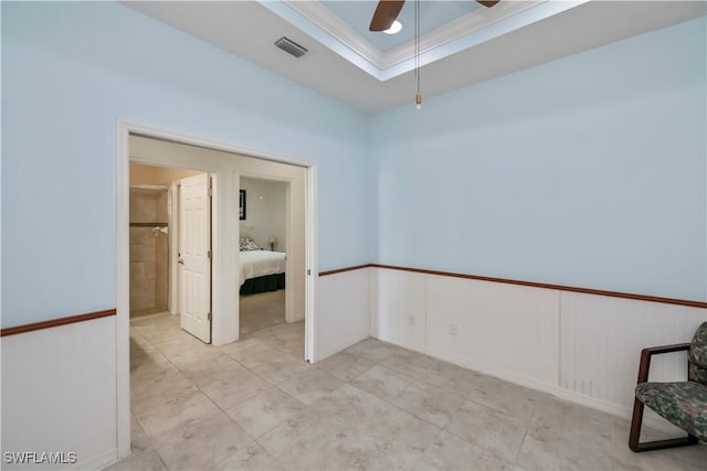 unfurnished room featuring light tile patterned floors, ornamental molding, a raised ceiling, and ceiling fan