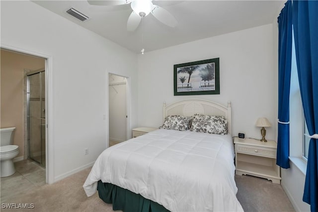 bedroom featuring ensuite bath, a spacious closet, carpet flooring, a closet, and ceiling fan