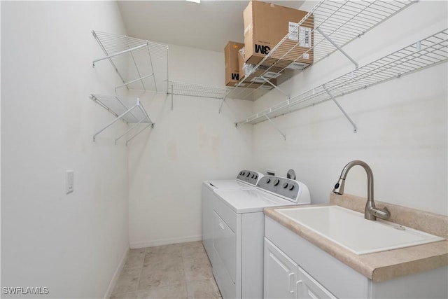 laundry room featuring cabinets, washing machine and dryer, and sink