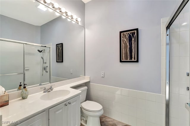 bathroom featuring a shower with door, vanity, and toilet