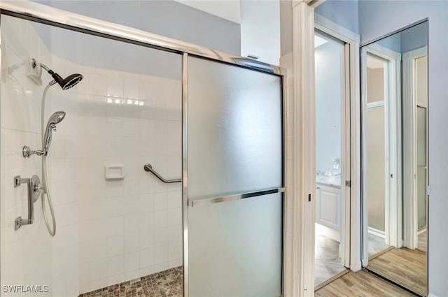 bathroom featuring hardwood / wood-style floors and a shower with shower door