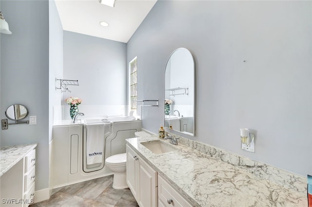 bathroom with vanity, toilet, and a washtub