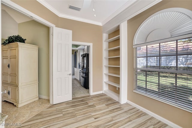 bedroom featuring ornamental molding, light hardwood / wood-style floors, and black fridge