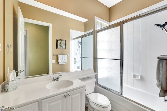 full bathroom featuring vanity, shower / bath combination with glass door, and toilet