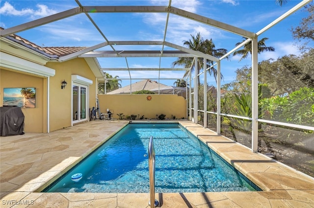 view of swimming pool featuring a lanai, grilling area, and a patio area