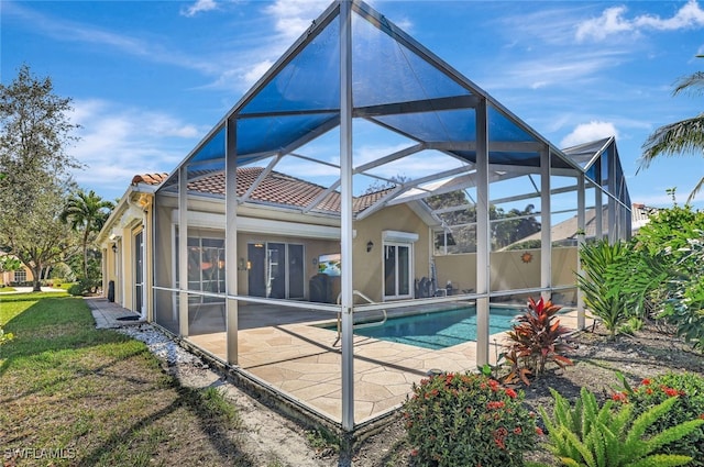 rear view of property featuring a patio area and glass enclosure