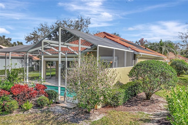 rear view of property featuring a lanai