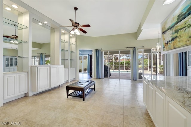 tiled living room featuring ceiling fan with notable chandelier and built in features