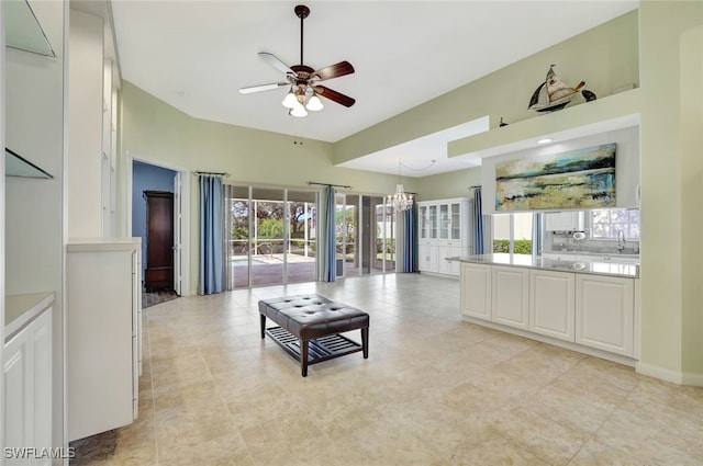 living room featuring sink and ceiling fan with notable chandelier