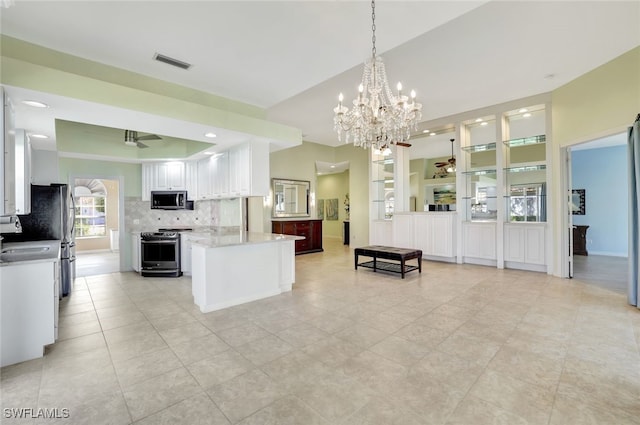 kitchen featuring white cabinetry, hanging light fixtures, ceiling fan, stainless steel appliances, and backsplash