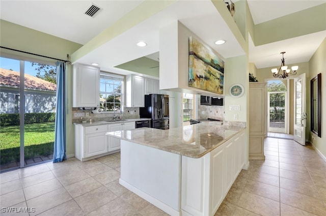 kitchen with white cabinetry, kitchen peninsula, light stone counters, and black appliances