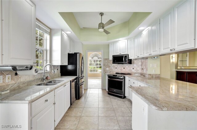 kitchen with sink, stainless steel appliances, white cabinets, and light stone countertops