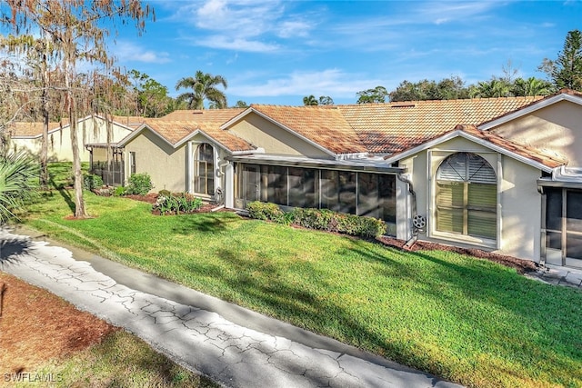 view of front of property featuring a front lawn and a sunroom