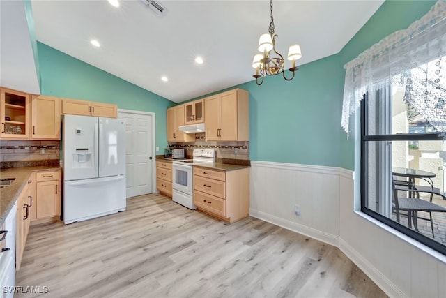 kitchen with hanging light fixtures, vaulted ceiling, light brown cabinets, and white appliances