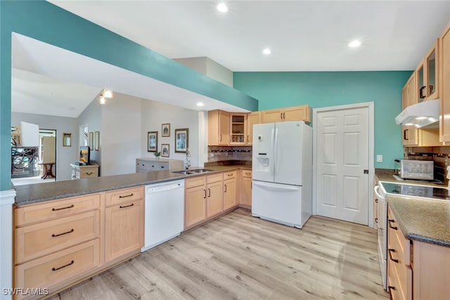 kitchen with light brown cabinetry, sink, vaulted ceiling, kitchen peninsula, and white appliances