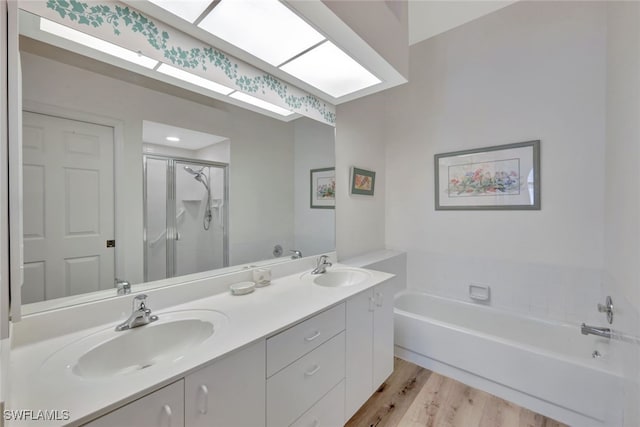 bathroom with vanity, a skylight, independent shower and bath, and wood-type flooring