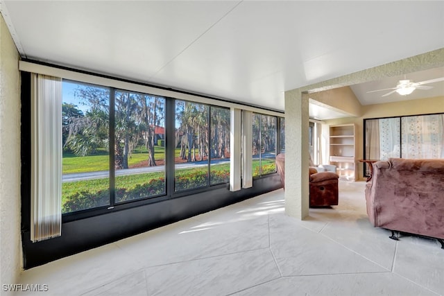 unfurnished sunroom with ceiling fan