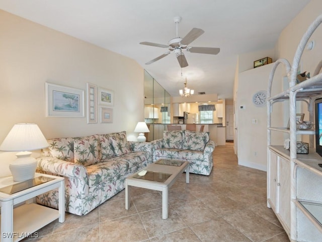 tiled living room featuring ceiling fan with notable chandelier and vaulted ceiling