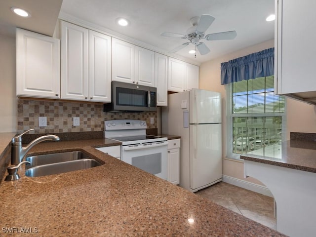 kitchen with tasteful backsplash, sink, white cabinets, and white appliances