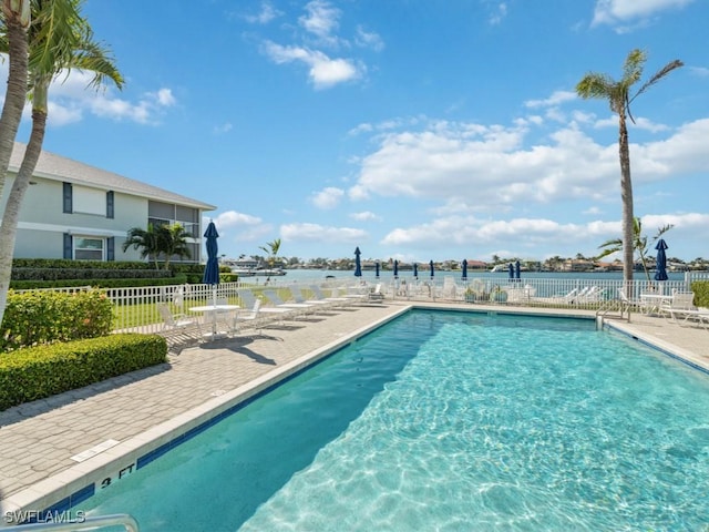 view of swimming pool with a water view and a patio area