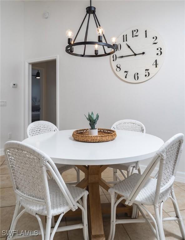 tiled dining room featuring a notable chandelier