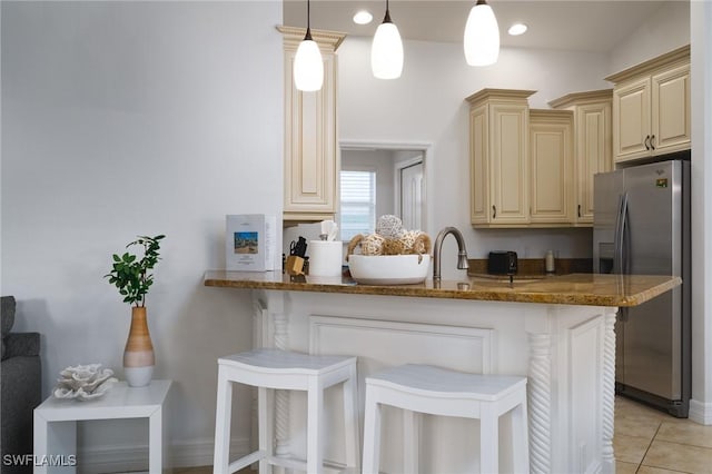 kitchen featuring pendant lighting, kitchen peninsula, a kitchen breakfast bar, and stainless steel fridge with ice dispenser