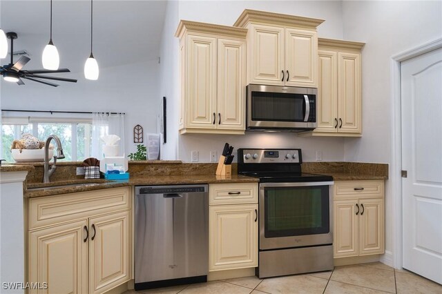 kitchen with sink, ceiling fan, appliances with stainless steel finishes, hanging light fixtures, and cream cabinetry