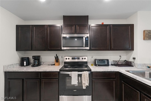 kitchen featuring stainless steel appliances, sink, and dark brown cabinets