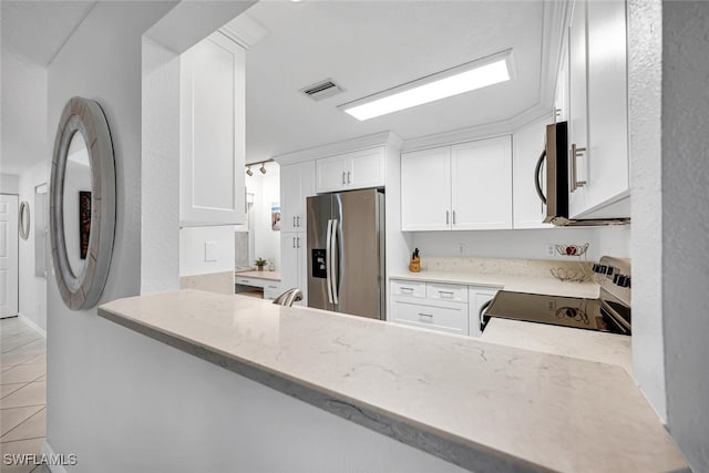 kitchen featuring white cabinetry, stainless steel appliances, kitchen peninsula, and light stone counters