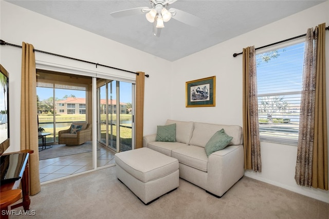 living room with light carpet, plenty of natural light, and a water view