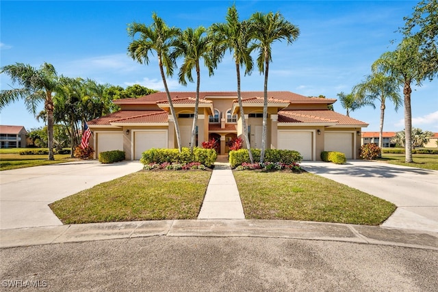 mediterranean / spanish home with a garage and a front lawn