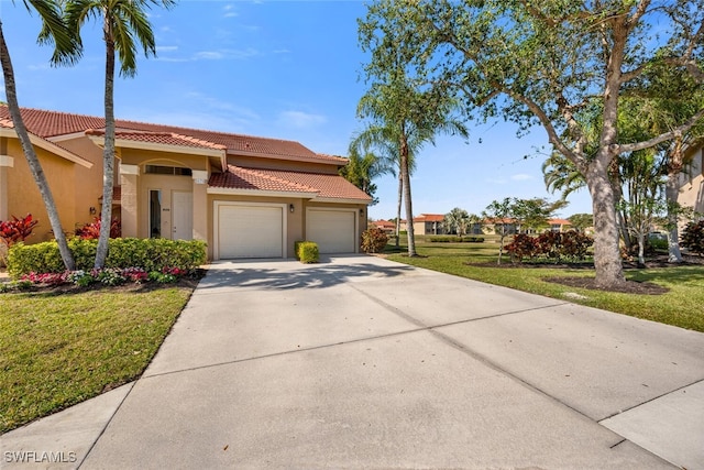 mediterranean / spanish home with a garage and a front lawn