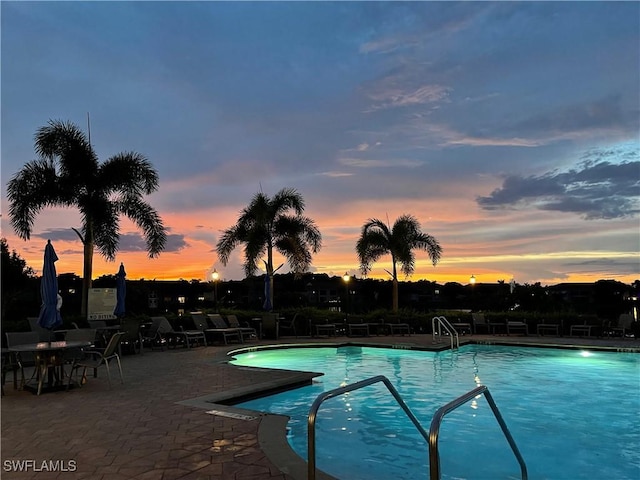 pool at dusk featuring a patio area