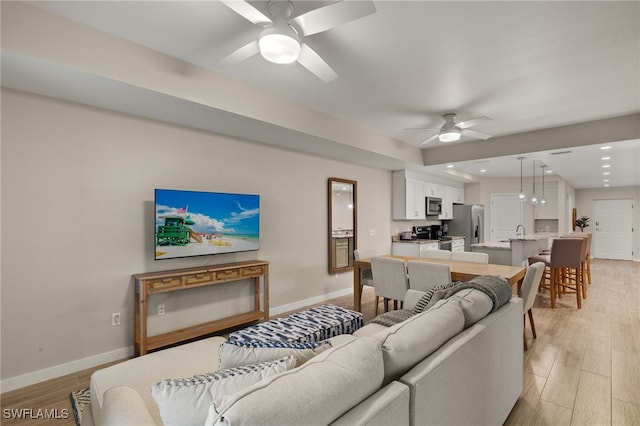 living room with ceiling fan and light wood-type flooring