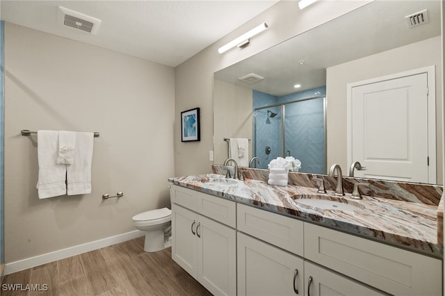 bathroom featuring walk in shower, vanity, toilet, and hardwood / wood-style floors