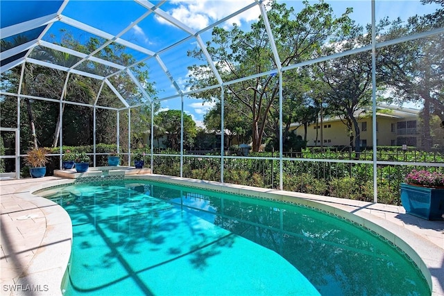 view of pool with glass enclosure and a patio area