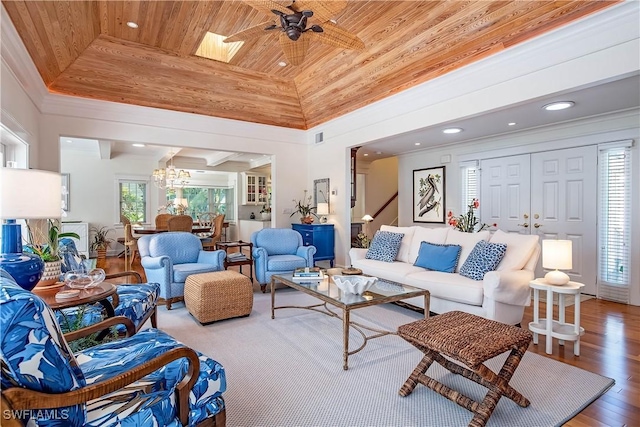 living room with hardwood / wood-style flooring, high vaulted ceiling, ornamental molding, ceiling fan with notable chandelier, and wooden ceiling